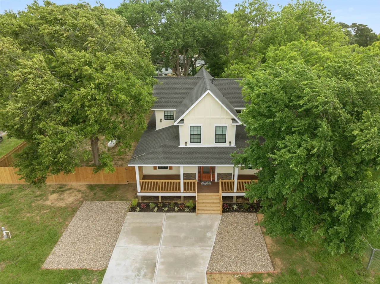 Aerial drone view of the property and front yard with surrounding tree canopy