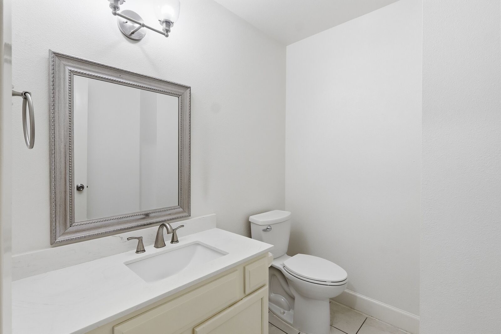 Downstairs half bath with vanity and framed mirror