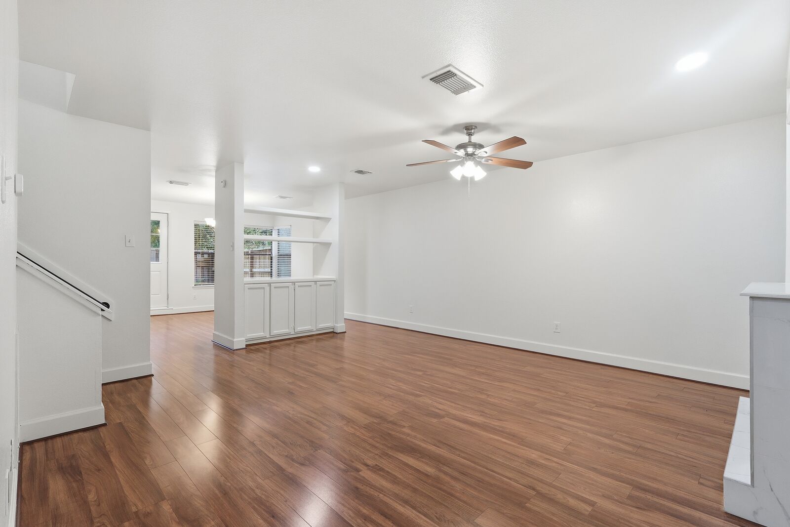 Living room with wood-look flooring and ceiling fan