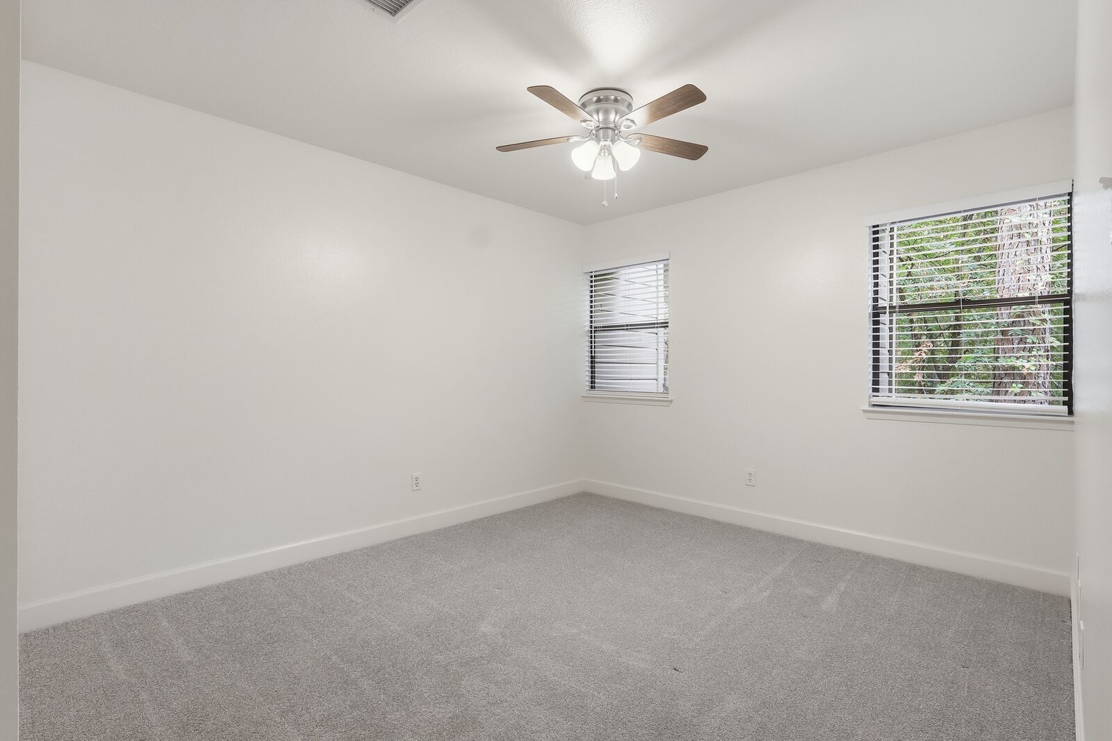 Secondary bedroom with ceiling fan and window