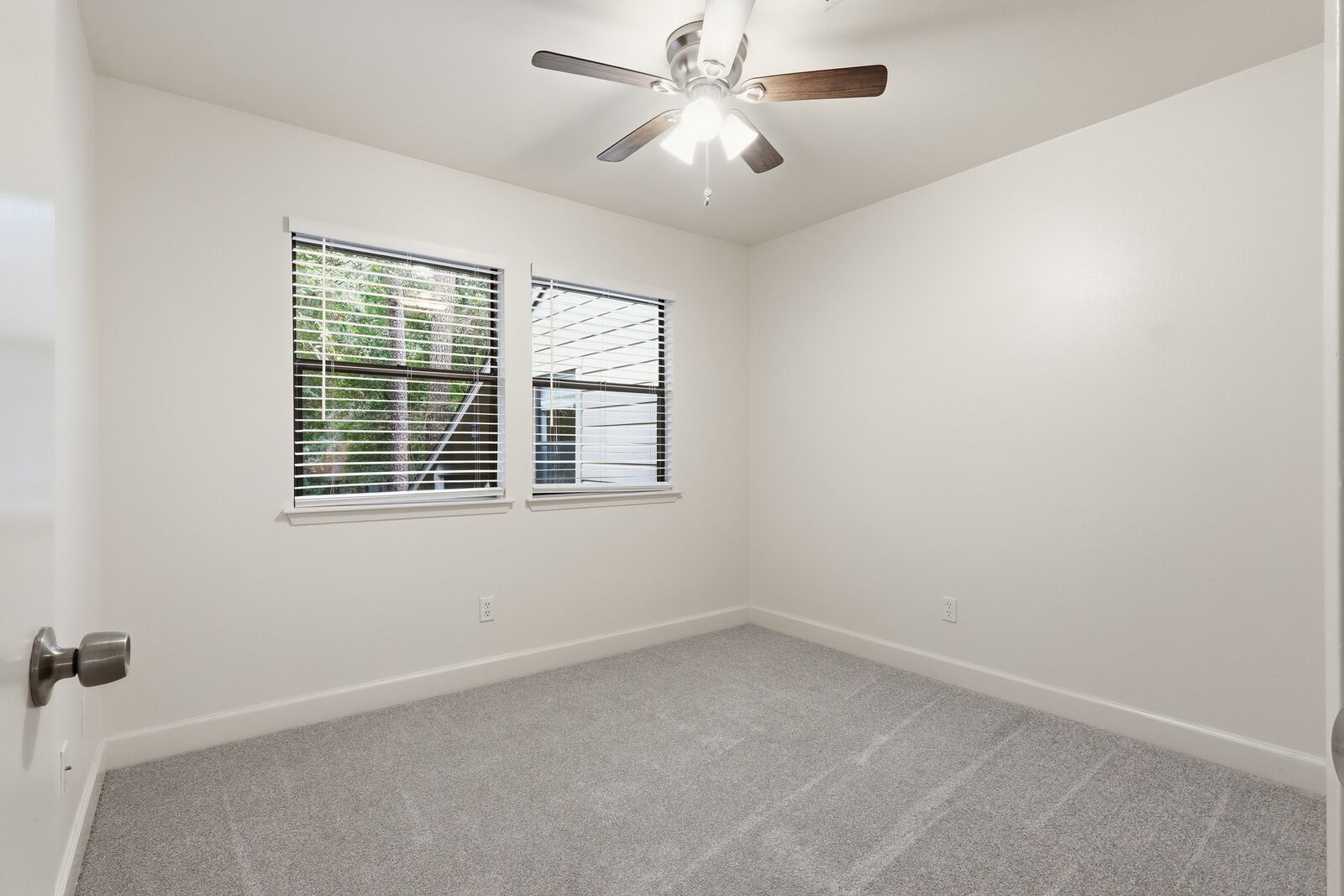 Bedroom with ceiling fan and two windows