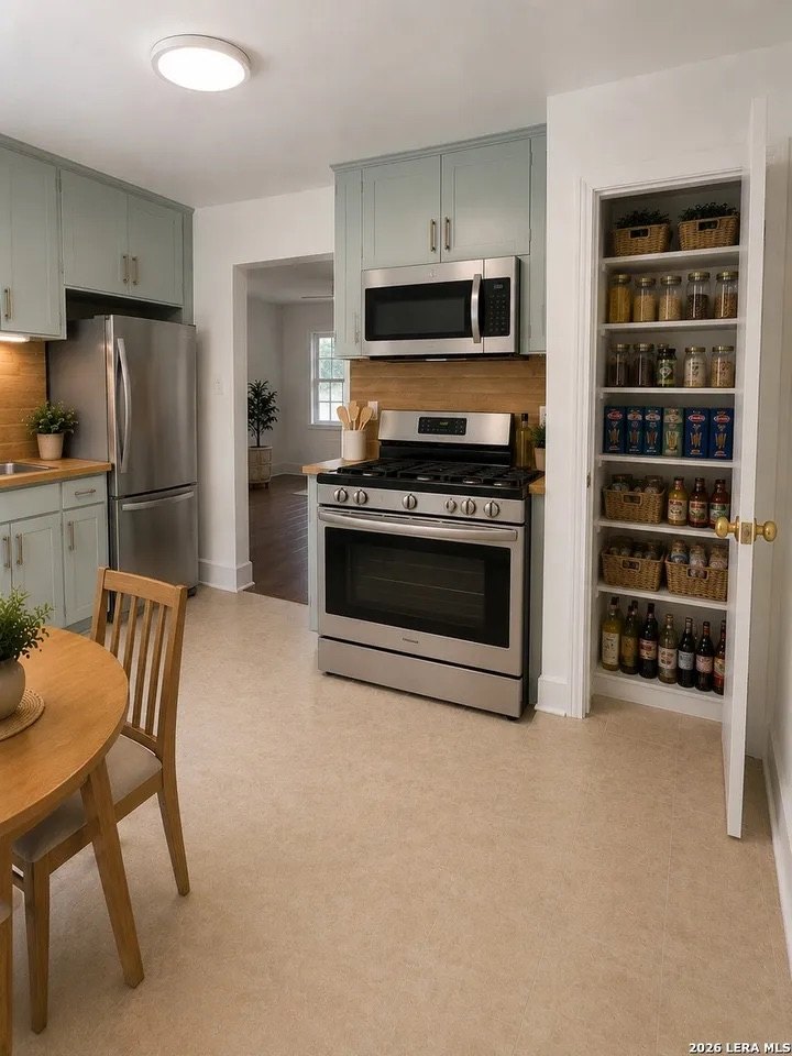 Kitchen with stainless range, microwave, refrigerator, and pantry shelving