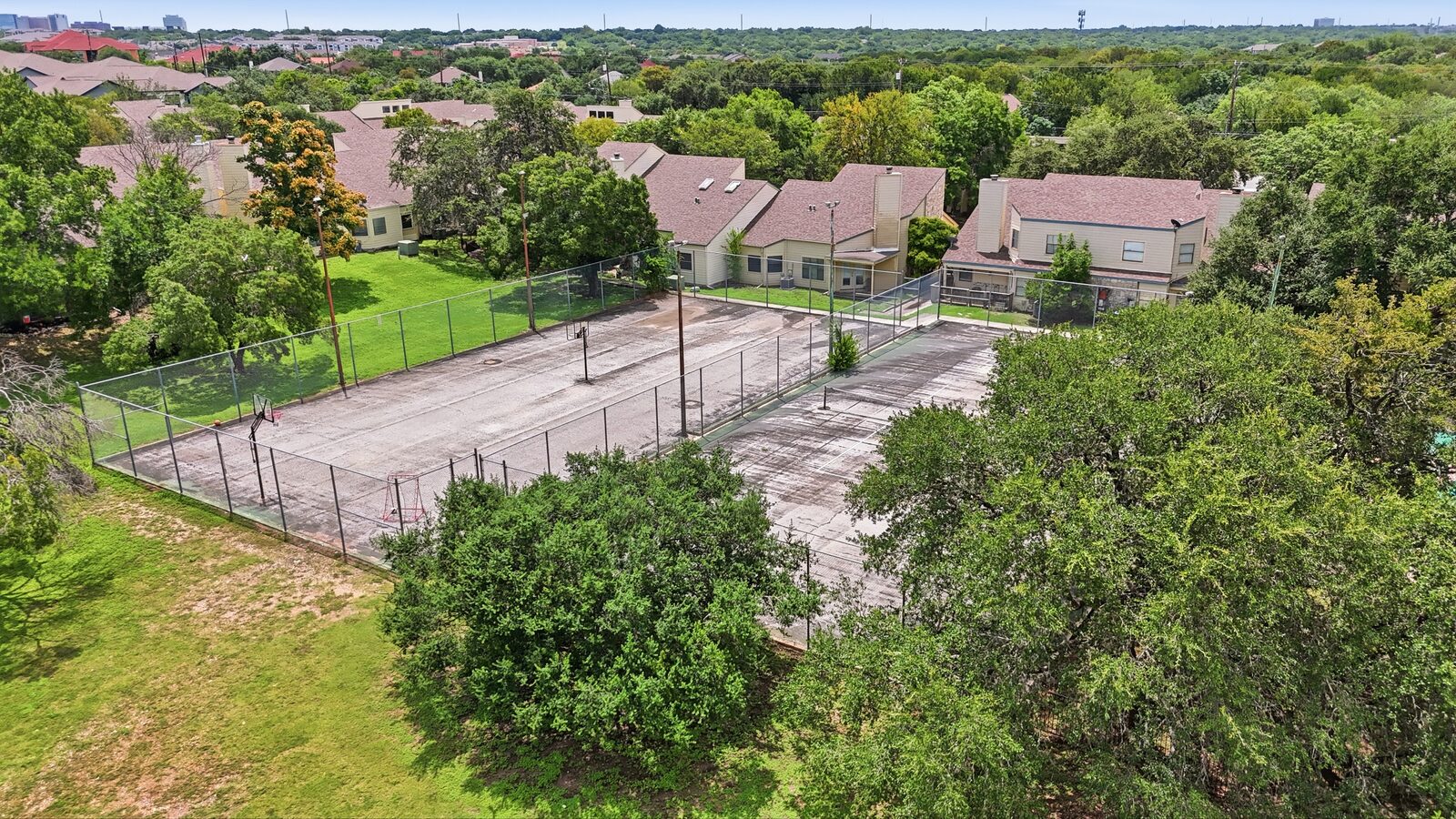 Aerial view of the community tennis and basketball courts with the pool beyond