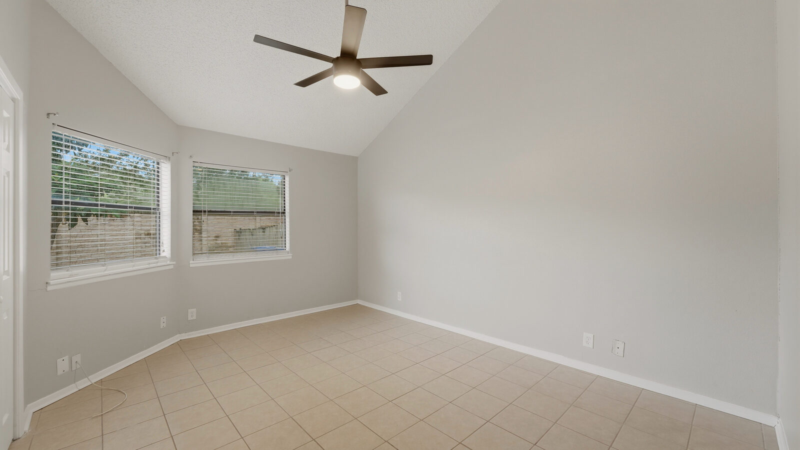 Bedroom with vaulted wood-beam ceiling, ceiling fan, and double closets